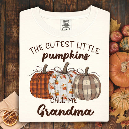 Ivory Comfort Colors® t-shirt with "The Cutest Little Pumpkins Call Me Grandma" text and three autumn pumpkins.