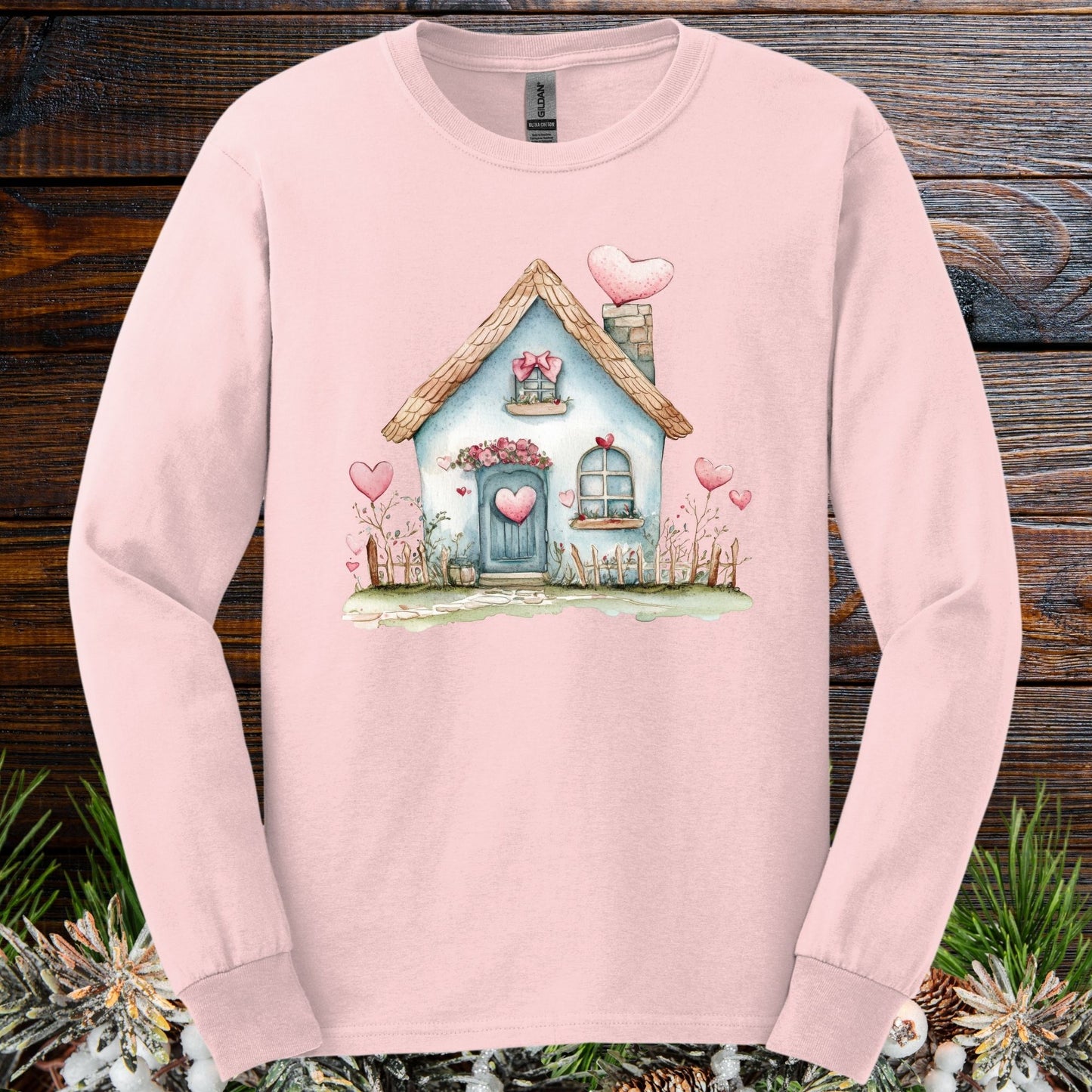 Light pink long sleeve tee with a watercolor blue cottage and pink hearts design.