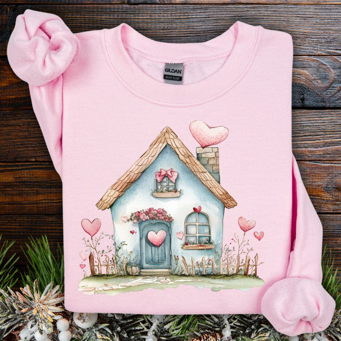 Light pink Gildan sweatshirt with a watercolor blue cottage and hearts design.