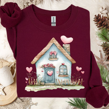 Maroon Gildan heavy blend sweatshirt with a watercolor blue cottage and pink hearts design.