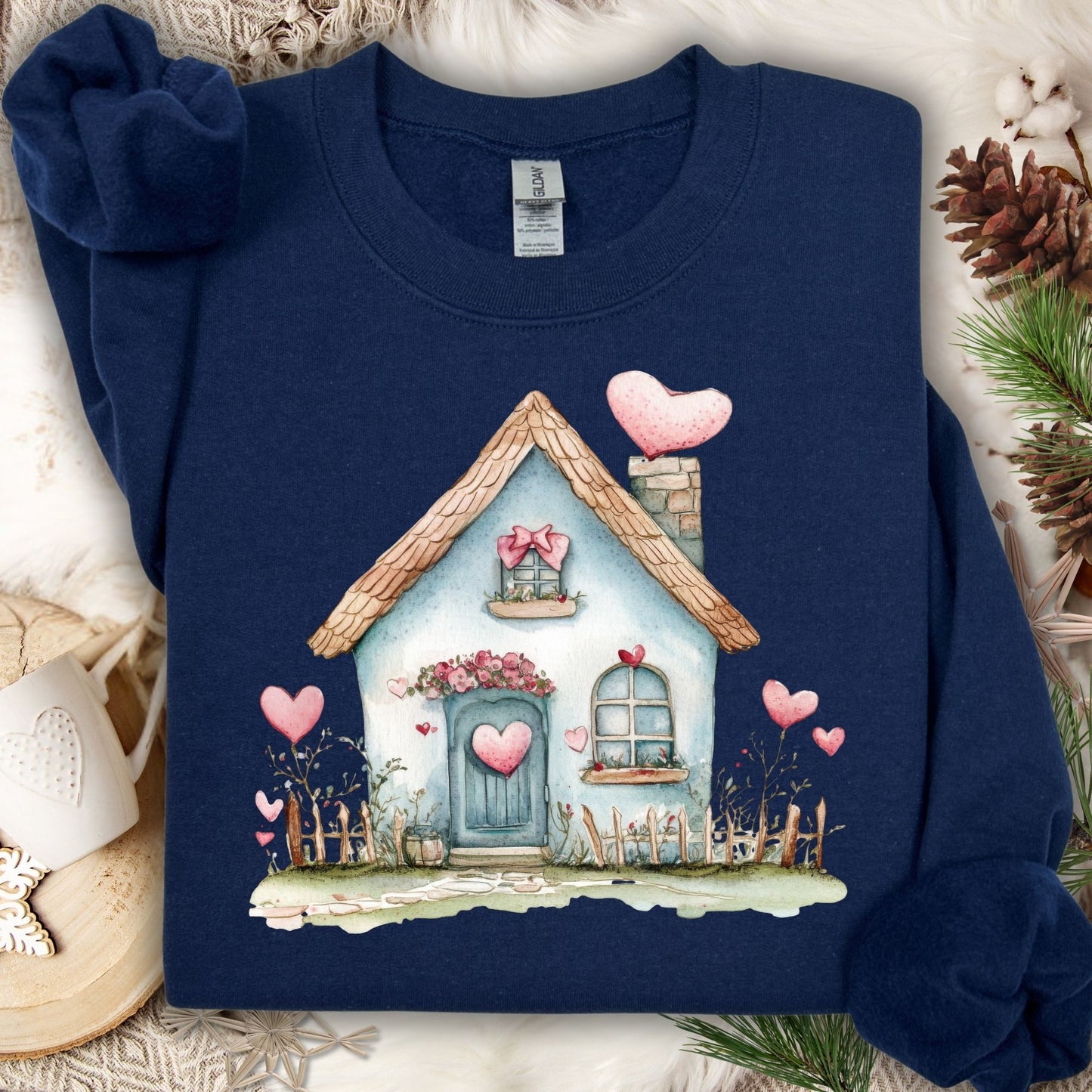 Navy blue cotton-polyester sweatshirt with a watercolor design of a blue cottage adorned with pink hearts.