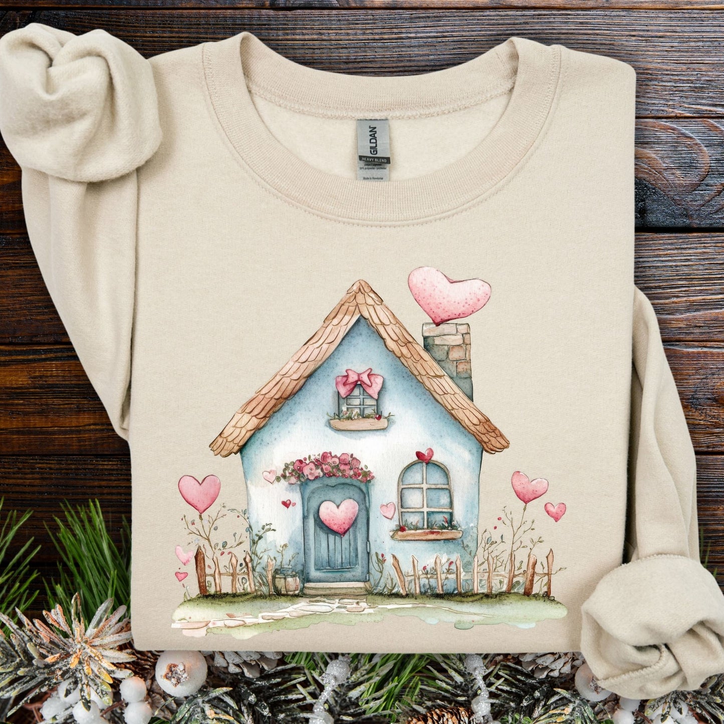 Sand heavy blend sweatshirt with a watercolor blue cottage and pink hearts design.