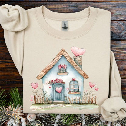 Sand heavy blend sweatshirt with a watercolor blue cottage and pink hearts design.