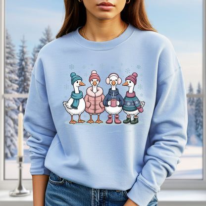 Light blue sweatshirt with four cartoon geese in winter clothes, hats, and mittens, drinking hot chocolate.