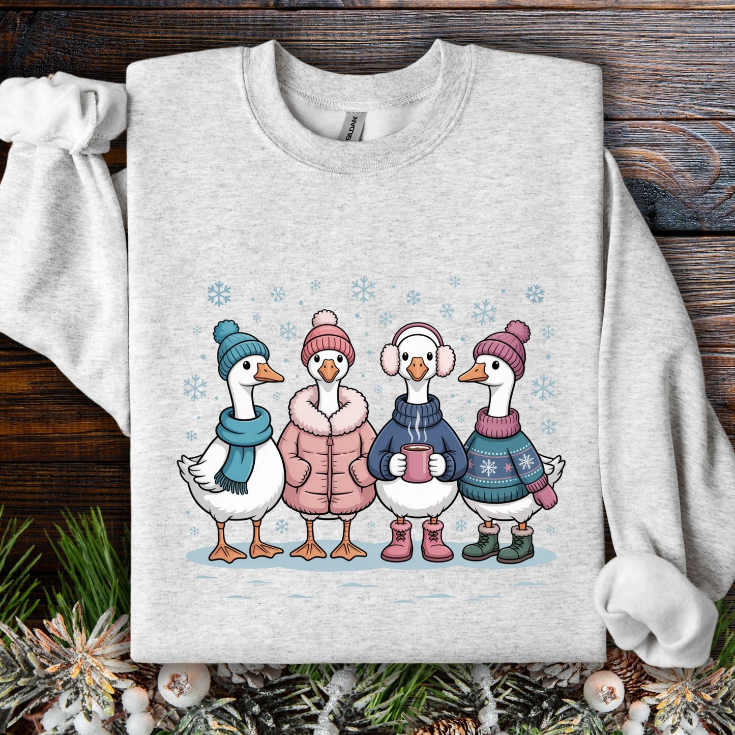 Ash S sweatshirt with four cute geese in winter sweaters, hats, and mittens, drinking hot chocolate.