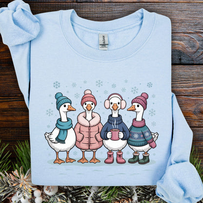 Light blue Gildan sweatshirt with four cartoon geese in winter clothes, drinking hot chocolate in the snow.