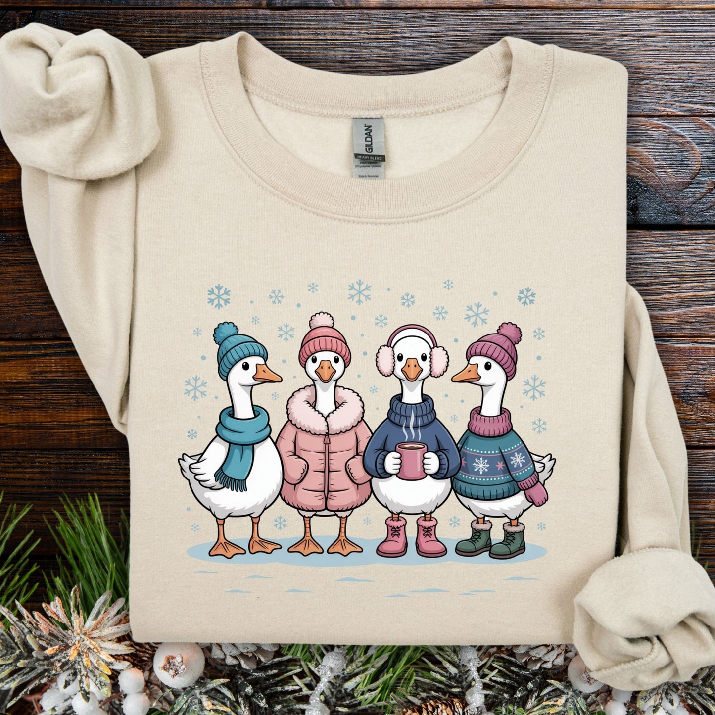 Sand S sweatshirt with four cute winter geese in sweaters, hats, and mittens drinking hot chocolate in snow.