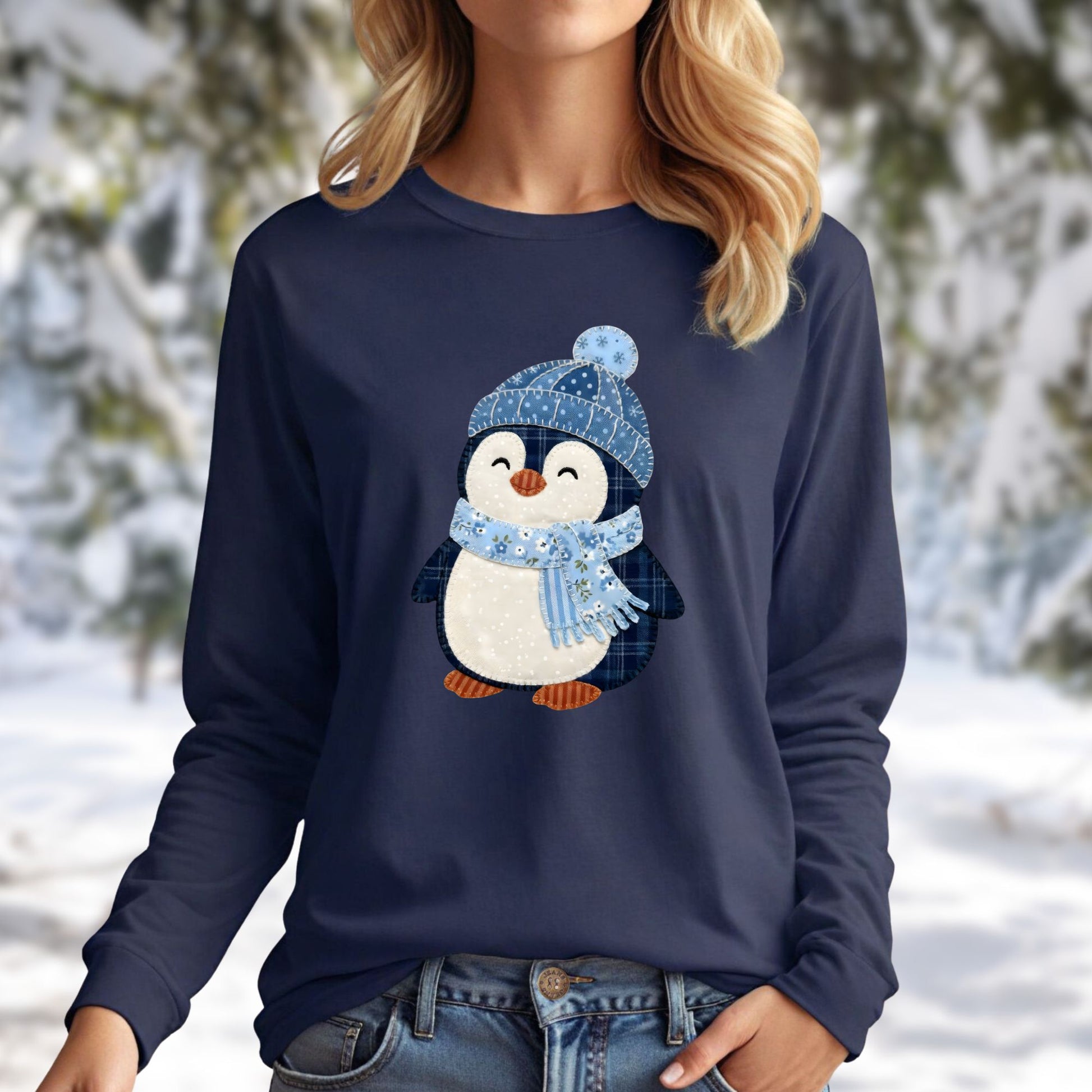 Navy long sleeve tee with a faux patchwork winter penguin wearing a blue hat and scarf.
