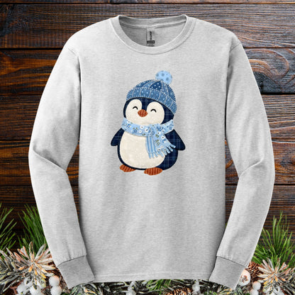 Ash long sleeve tee with a faux patchwork winter penguin wearing a blue hat and scarf.