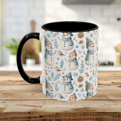 White ceramic mug with watercolor snowmen, birds, and pinecones, black interior and handle.