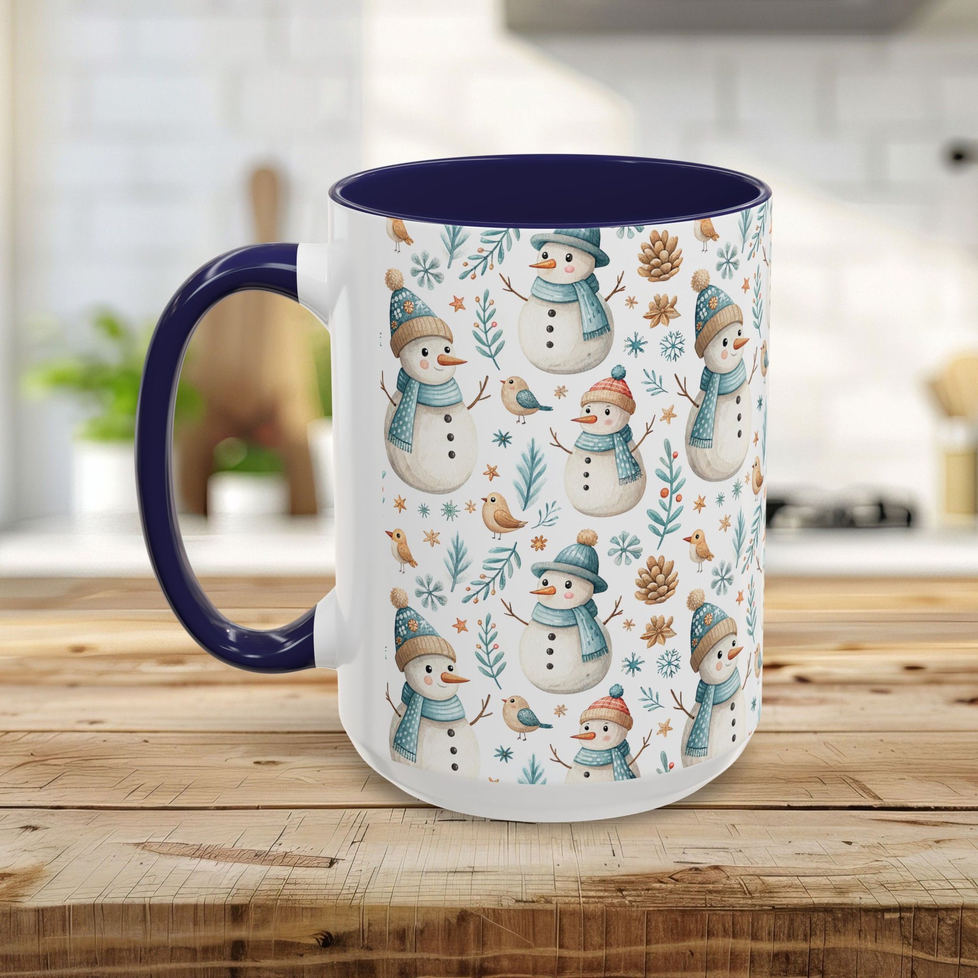 White ceramic mug with watercolor snowmen, birds, and pinecones, featuring a navy blue interior and handle.