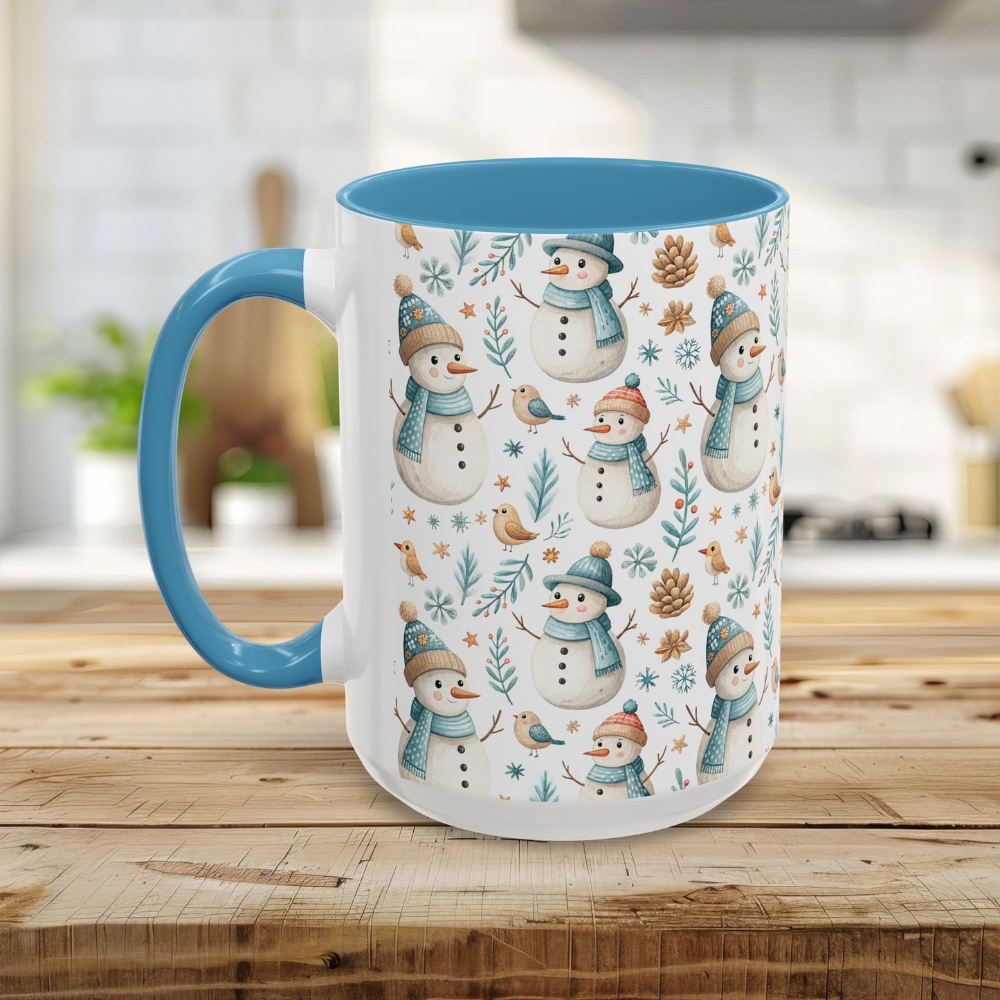 White ceramic 15oz mug with blue interior/handle, featuring a watercolor pattern of snowmen, birds, and pinecones.