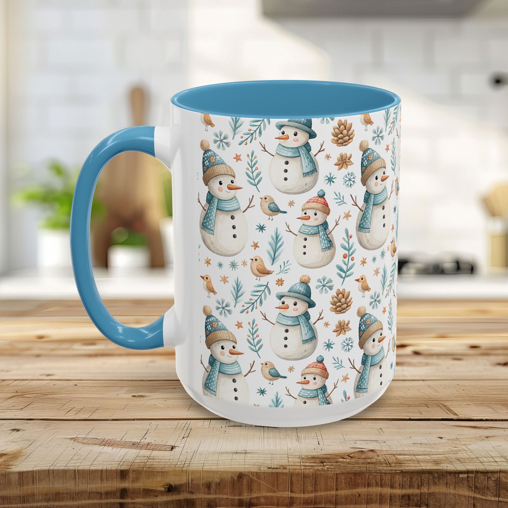 White ceramic 15oz mug with blue interior/handle, featuring a watercolor pattern of snowmen, birds, and pinecones.