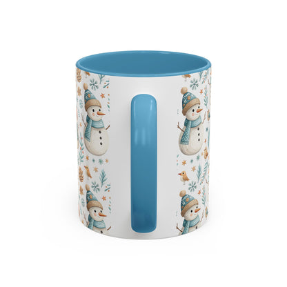 White ceramic mug with blue interior and handle, featuring watercolor snowmen, birds, and pinecones.