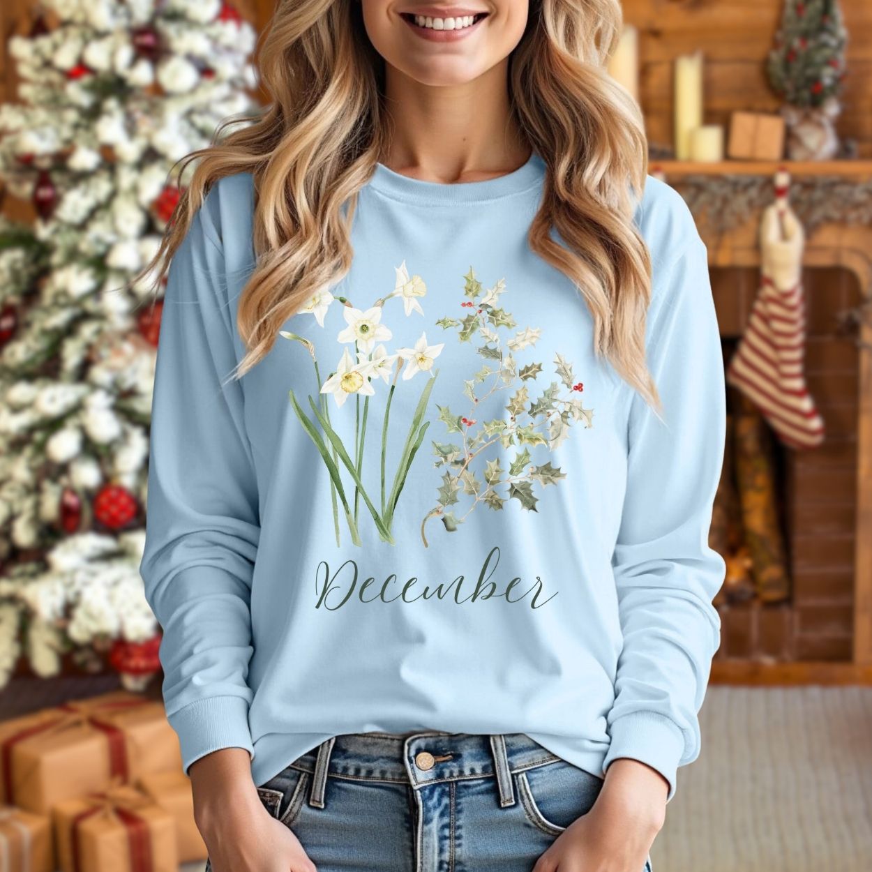 Light blue long-sleeve tee with watercolor narcissus, holly, and "December" text, worn by a woman.