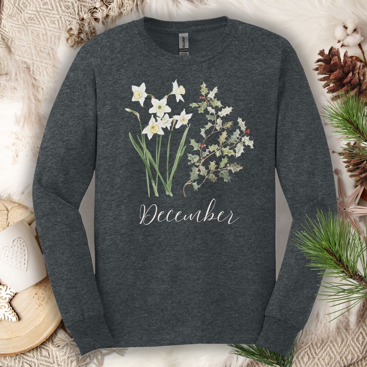 Dark Heather long-sleeve tee with watercolor narcissus, holly, and "December" script.