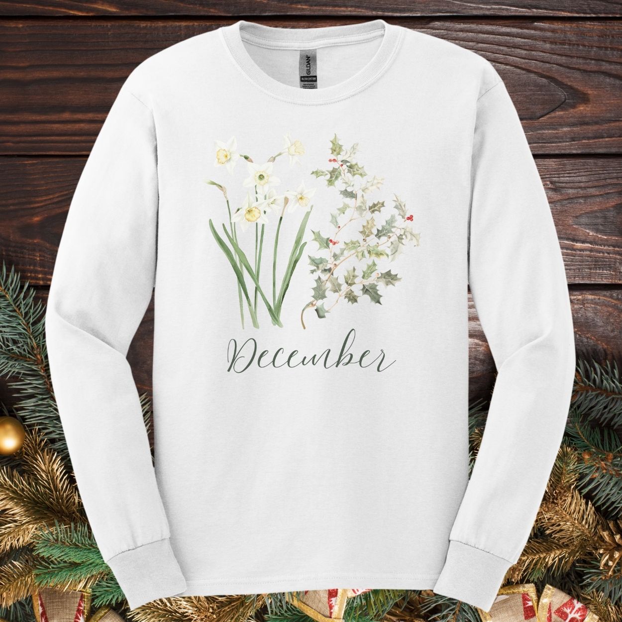 White long-sleeve tee with watercolor narcissus, holly, and "December" script.