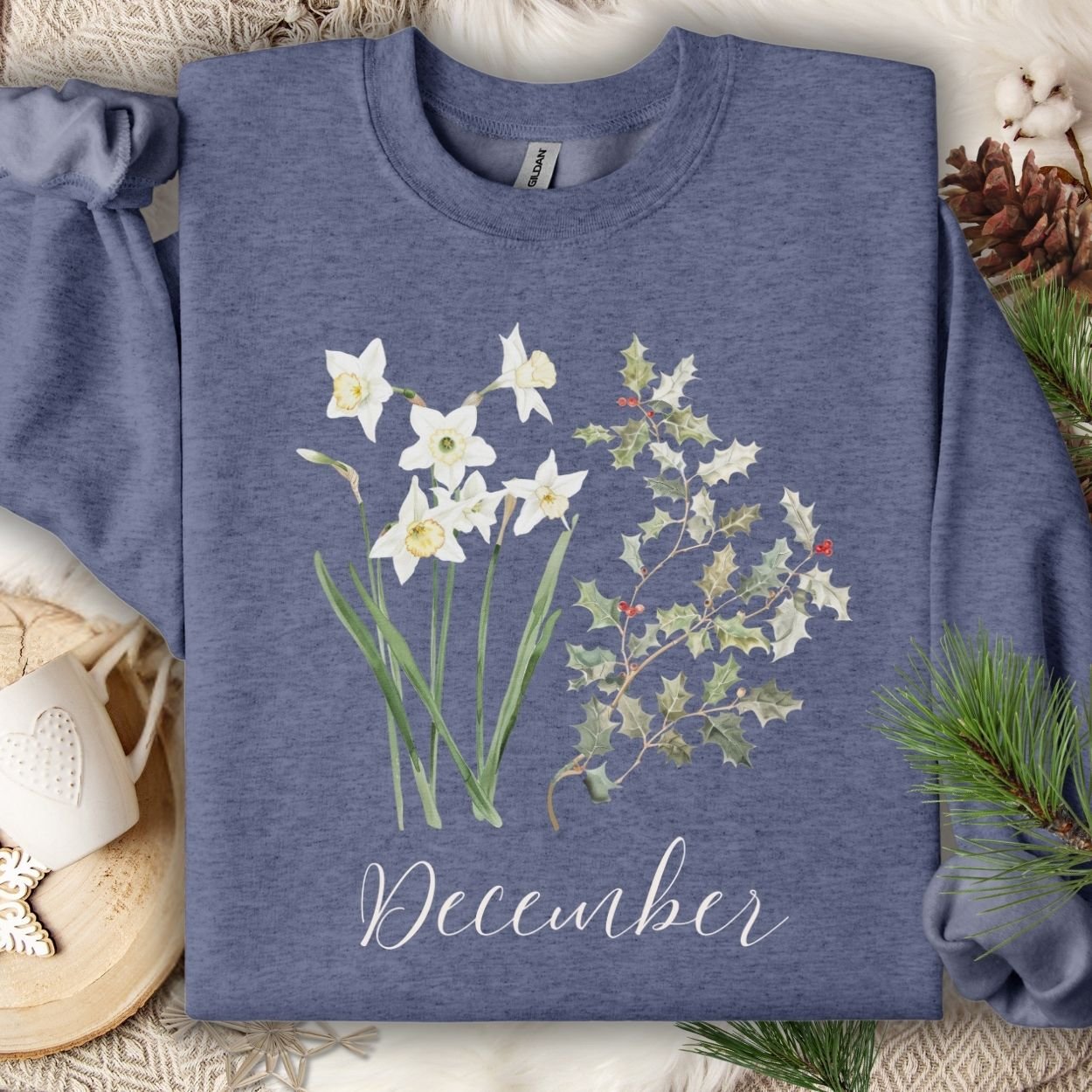 Unisex crewneck sweatshirt in heather blue with watercolor narcissus, holly, and "December" script.