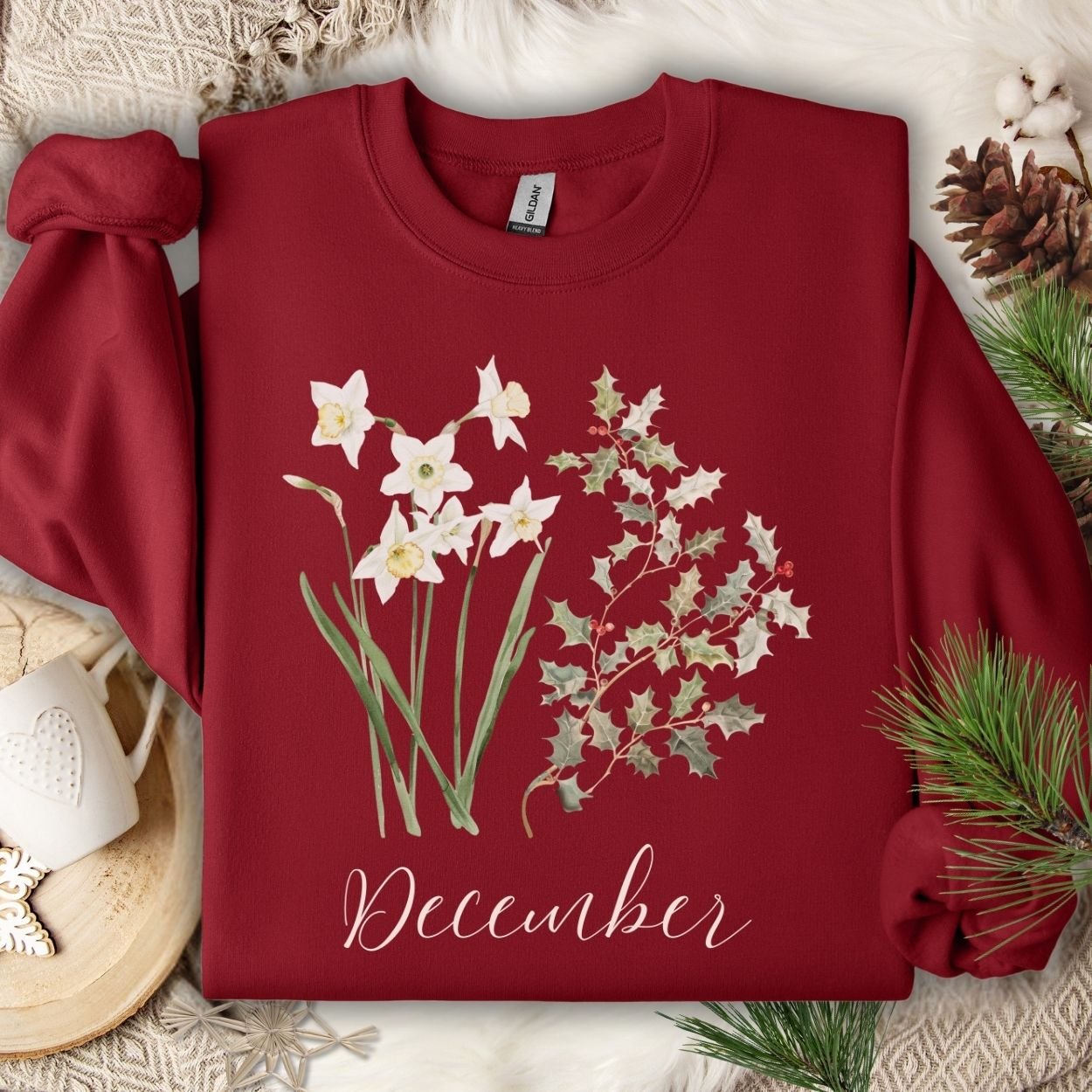 Cardinal Red unisex sweatshirt with watercolor narcissus, holly, and "December" script.
