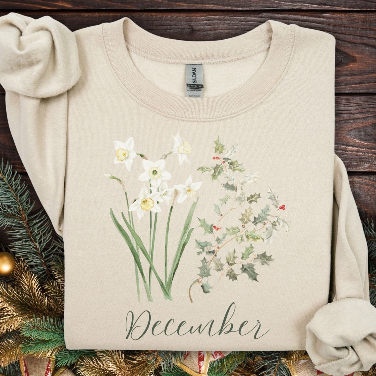 Sand unisex sweatshirt with watercolor narcissus, holly, and "December" script.