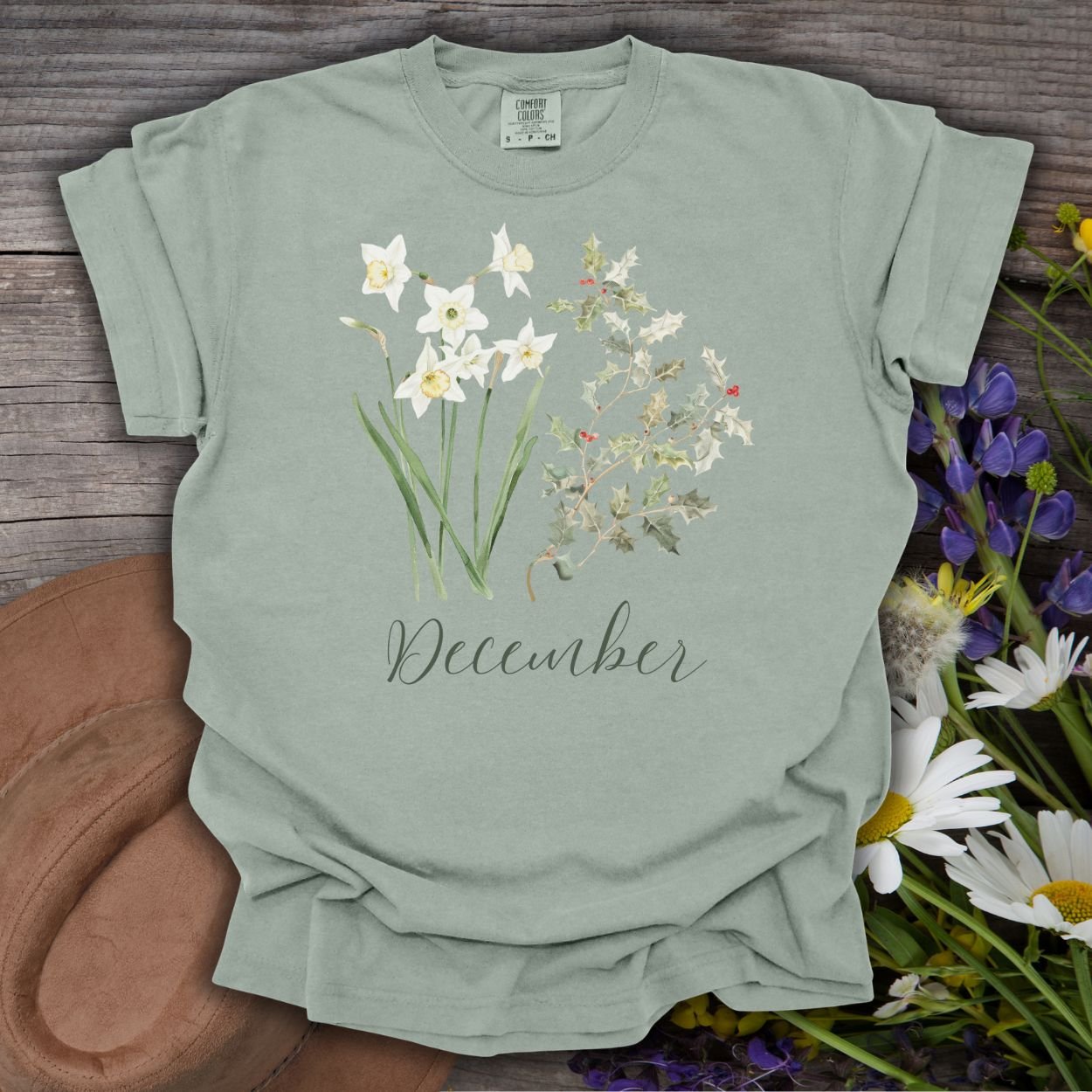 Bay green garment-dyed cotton t-shirt with watercolor narcissus, holly, and "December" script.