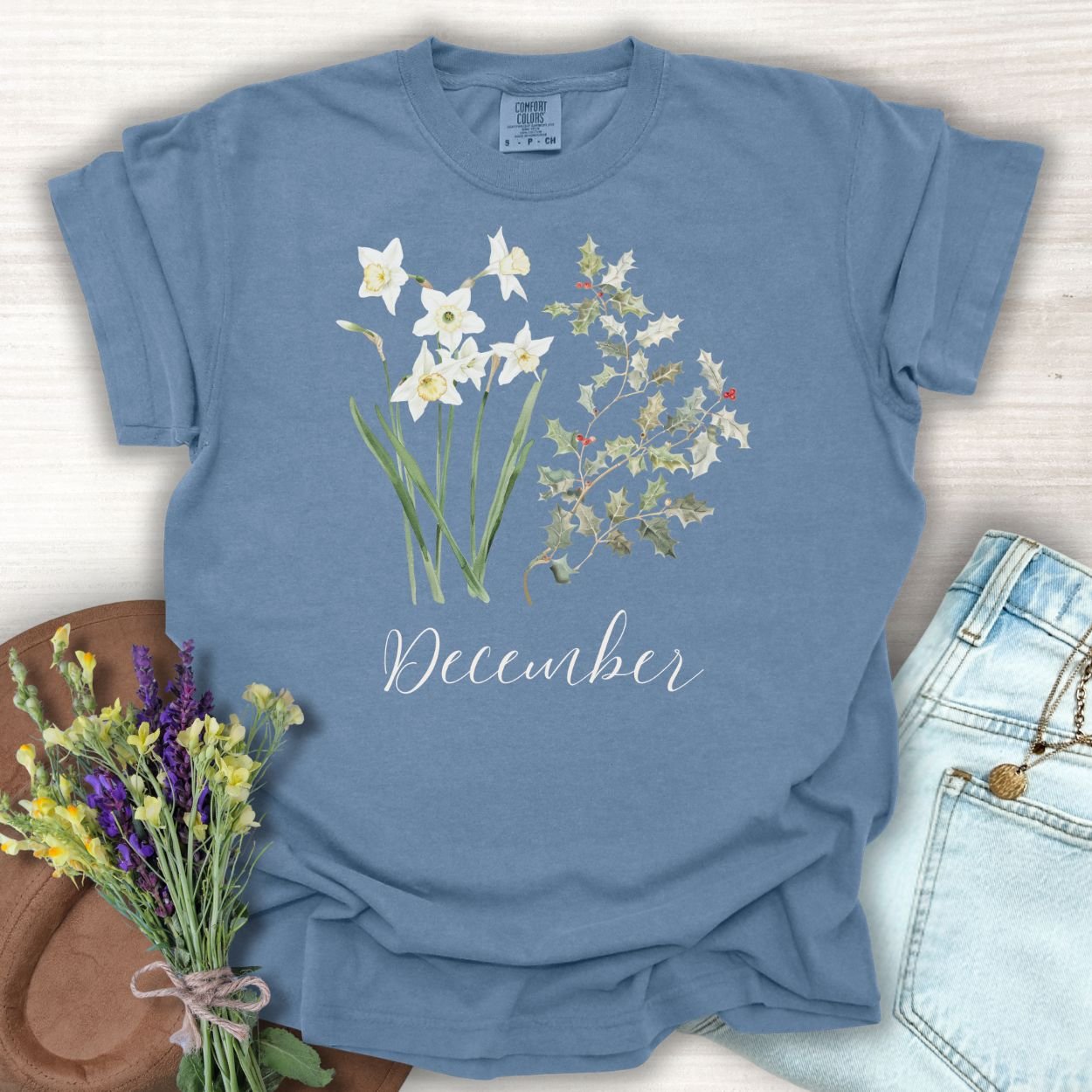 Blue Jean S t-shirt with watercolor narcissus, holly, and "December" text.