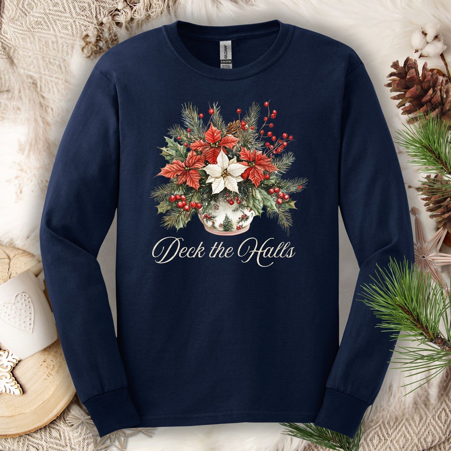 Navy long sleeve tee with a watercolor poinsettia arrangement in a ceramic vase and "Deck the Halls" script.