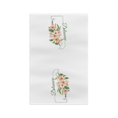 White microfiber tea towel with two Delaware state silhouettes, each adorned with delicate peach blossoms.