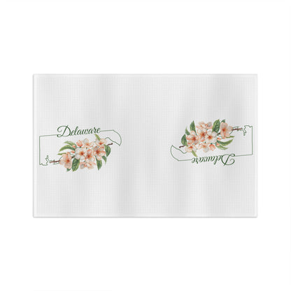 White microfiber tea towel with peach blossoms and "Delaware" text within a state silhouette.