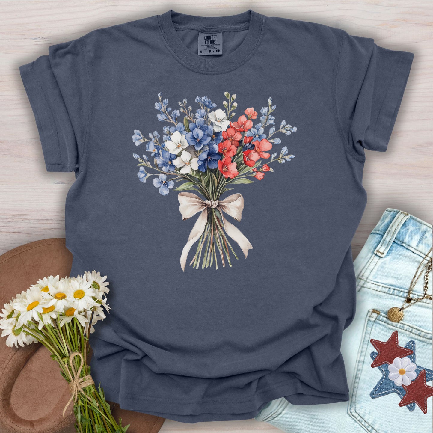 Denim S t-shirt with a patriotic red, white, and blue floral bouquet tied with a cream ribbon.
