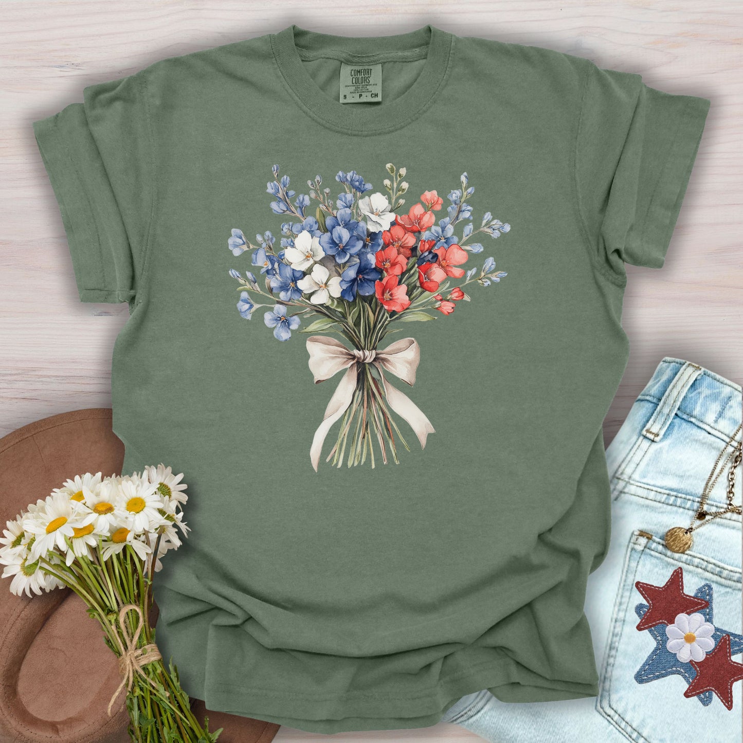 Moss green t-shirt with a vintage patriotic floral bouquet of red, white, and blue flowers tied with a ribbon.