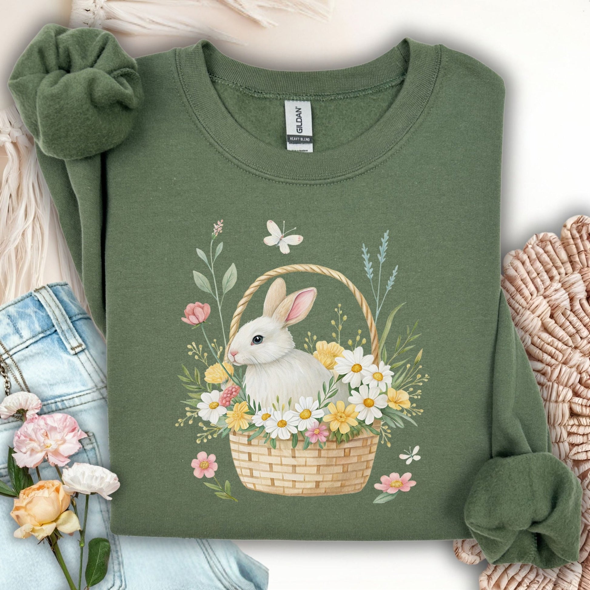 Military Green sweatshirt with a watercolor design of a white rabbit in a floral basket with wildflowers and butterflies.