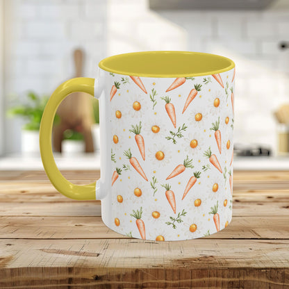 White ceramic mug with watercolor carrots and daisies, yellow interior and handle, on a wooden surface.