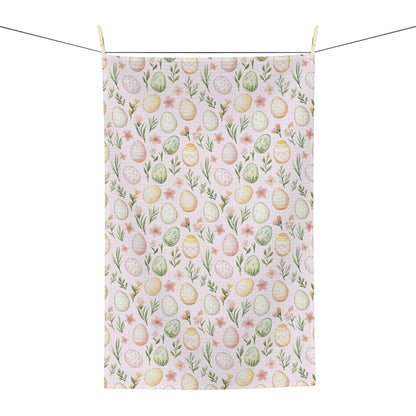 Pastel pink microfiber tea towel with watercolor Easter eggs and spring floral design, hanging from a clothesline.