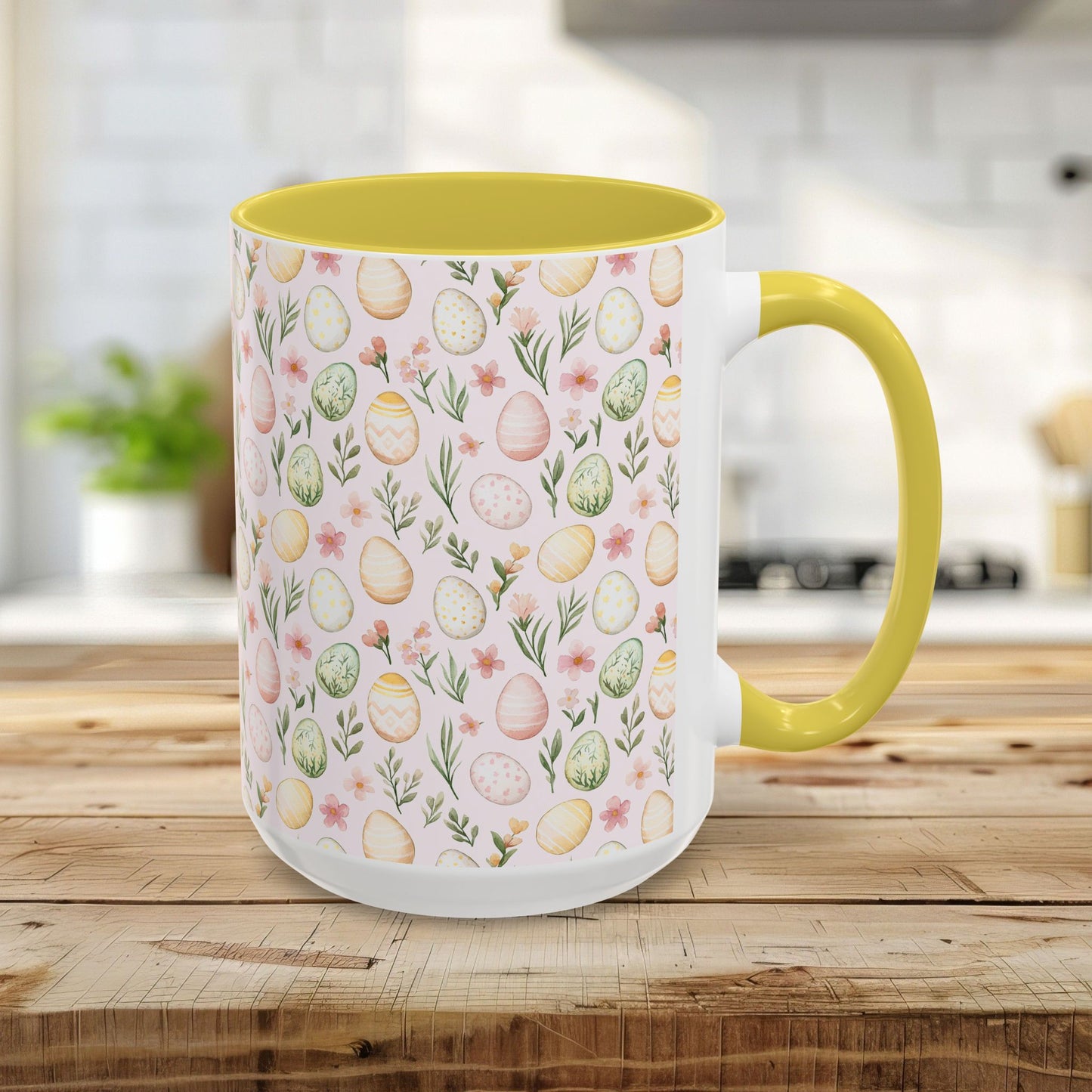 15oz ceramic mug with a pastel watercolor egg pattern, yellow interior, and C-shaped handle.