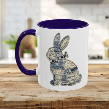 White ceramic mug with a purple handle and interior, featuring a blue patchwork bunny design.