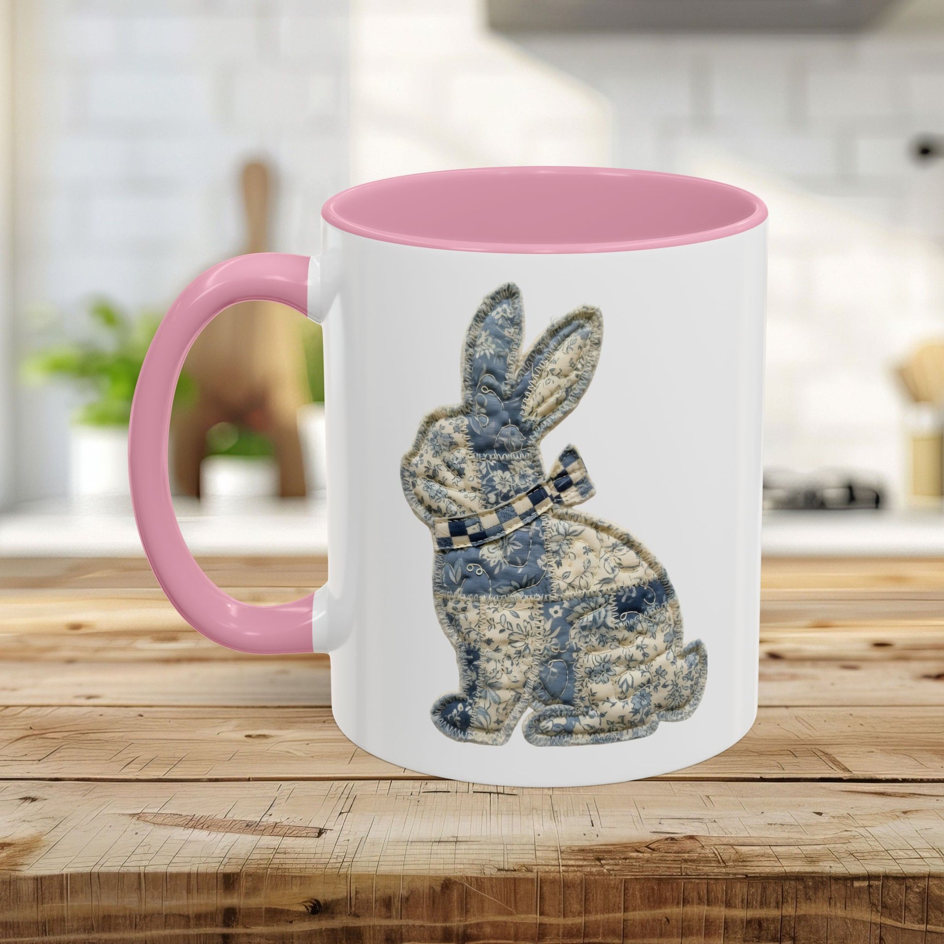 White ceramic 11oz mug with pink interior and handle, featuring a blue patchwork bunny illustration.