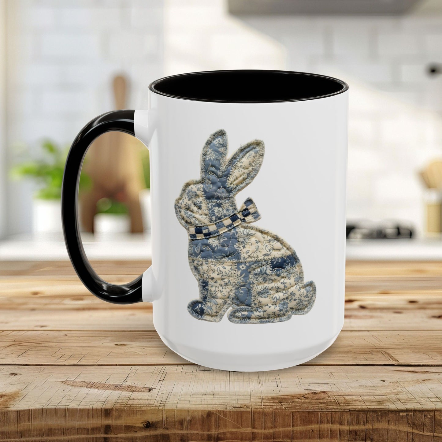 White 15oz ceramic mug with black handle and interior, featuring a blue and stone patchwork bunny illustration.
