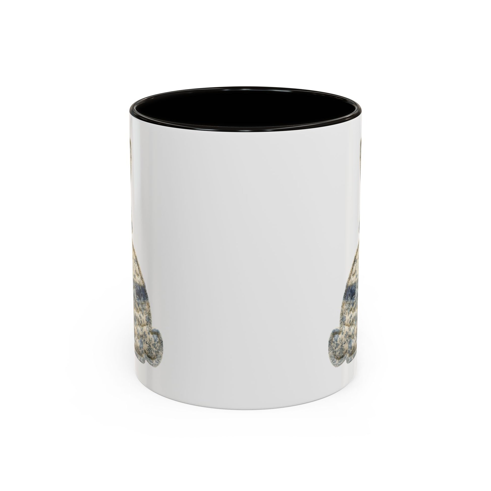 White ceramic coffee mug with black interior, featuring a partial patchwork bunny illustration in muted blues and stone tones.