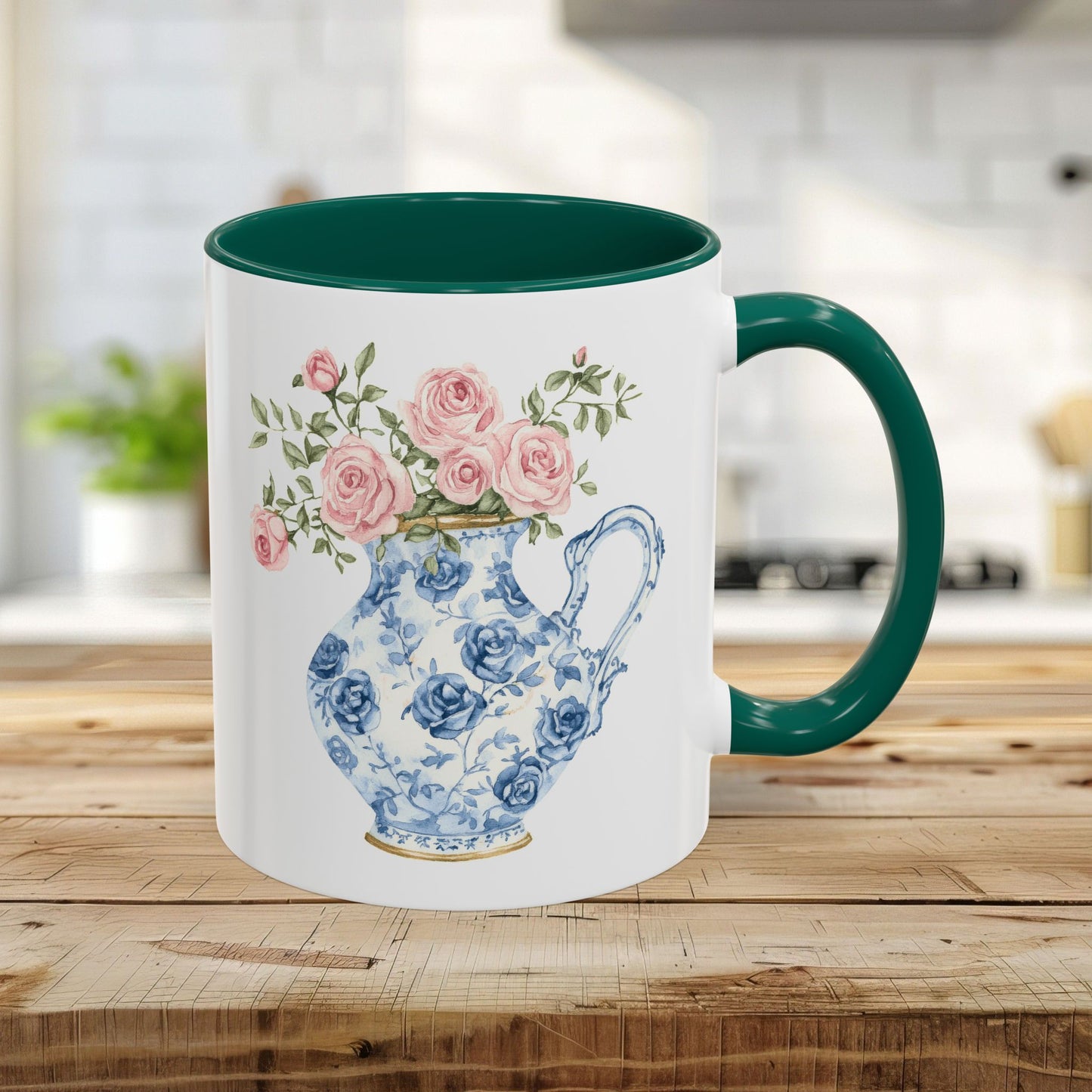 White ceramic 11oz mug with a green handle and interior, featuring a blue-and-white rose pitcher design.