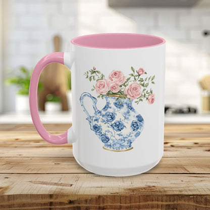 White ceramic mug with pink handle and interior, featuring a blue-and-white porcelain pitcher with pink roses.