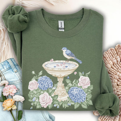 Military Green Gildan sweatshirt with a watercolor bird bath, blue bird, pink roses, and blue hydrangeas.