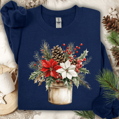 Navy Gildan sweatshirt with watercolor poinsettia bouquet in a rustic metal jar, surrounded by pinecones and holly.
