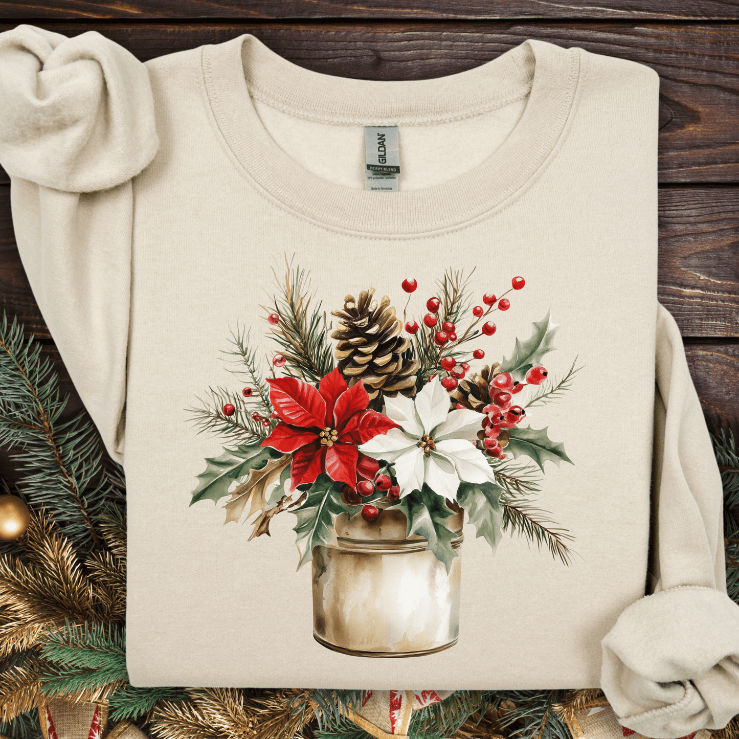 Sand Gildan sweatshirt with watercolor poinsettia, evergreen, and berry bouquet in a rustic metal jar.