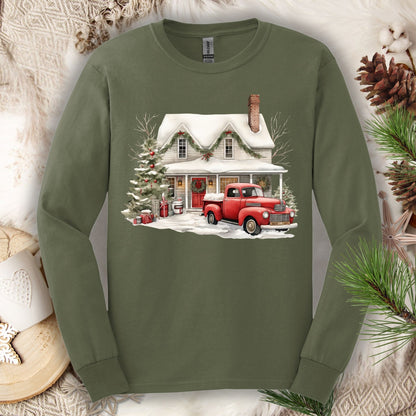 Military green long sleeve tee with a watercolor farmhouse Christmas scene and red pickup truck.