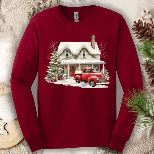 Red Gildan long-sleeve sweatshirt with a watercolor farmhouse, red vintage truck, and Christmas tree design.