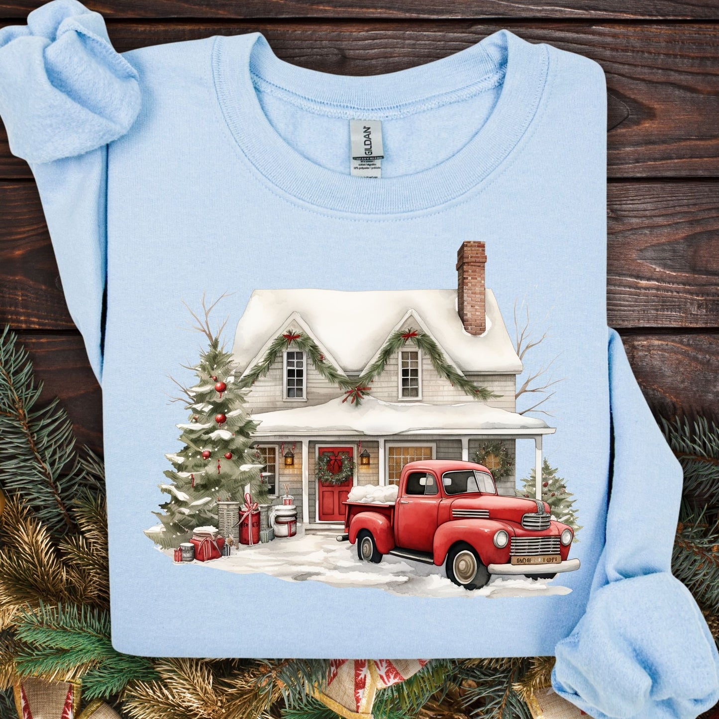 Light blue Gildan sweatshirt with a watercolor farmhouse, red vintage truck, and Christmas tree in snow.