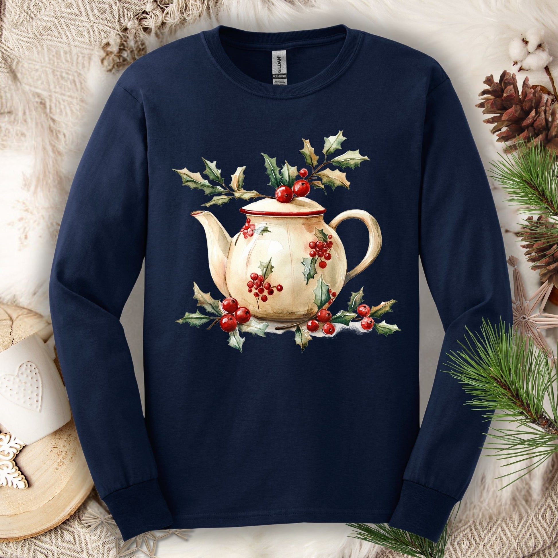 Navy long-sleeve tee with a watercolor farmhouse Christmas teapot, holly, and evergreens design.