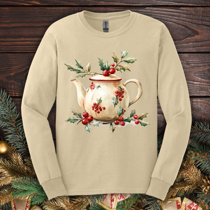 Sand long sleeve tee with a watercolor farmhouse Christmas teapot design, holly, and red berries.