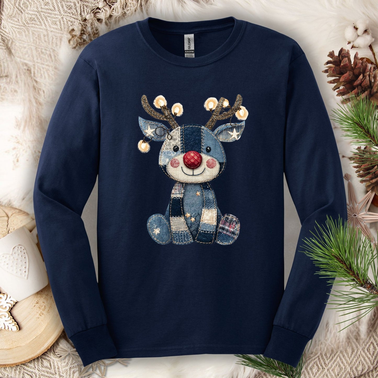 Navy long sleeve tee with a faux denim patchwork Rudolph print, sparkling Christmas lights on antlers.